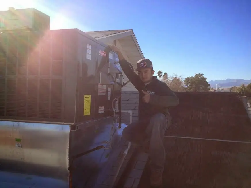 HVAC technician performing Air Duct Cleaning on a rooftop unit in Norcross